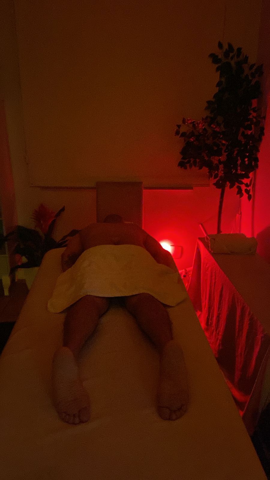 Ambiente de massagem com iluminação vermelha e clima intimista